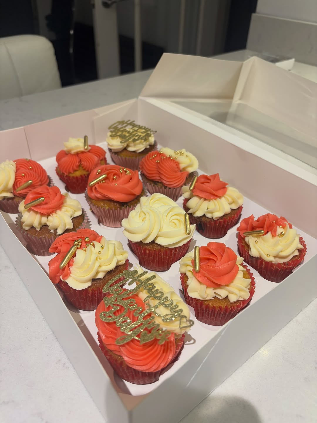 Boxed birthday cupcakes piped in red and cream buttercream by Cakes by Leila
